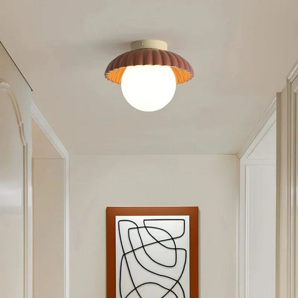 Lampa sufitowa z mlecznym kloszem zapewniająca ciepłe oświetlenie w holu
